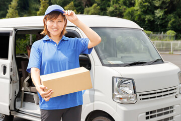 引越しや軽貨物ドライバーなど物流関係の仕事をする女性が笑顔で挨拶をする。青いポロシャツと帽子のユニフォーム。
