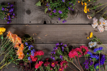 Fototapeta na wymiar Wild Colorful Rustic Flowers Bouquet from Daisy, Chrysanthemum and Others on Wooden Rustic Table. Mothers Day, Summer and Spring Holidays Wallpaper.