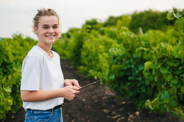 Portrait happy woman working with digital tablet gardening in organic farm. Fresh vegan food...