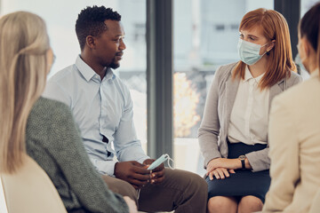 Covid, corporate and employees in a meeting for business, networking and collaboration in office at work. Team of workers, business people and staff talking with face mask at a professional company