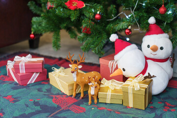 Fototapeta na wymiar Present boxes and snowman dolls decoration under Christmas tree background