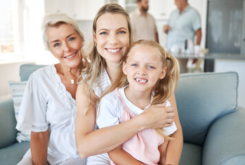 Family, love and generations with a girl, mother and grandmother sitting on a living room sofa in...