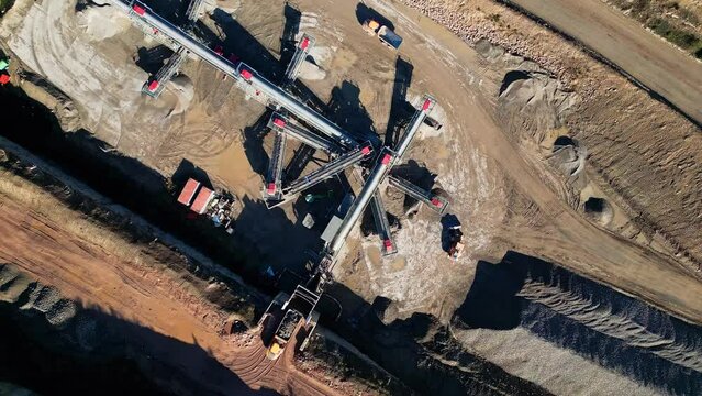 Aerial view of a sand, gravel mine quarry. Drone flight. Aerial view industrial of opencast mining quarry with lots of machinery at work. Extraction of aggregate,  stone, sand, minerals.