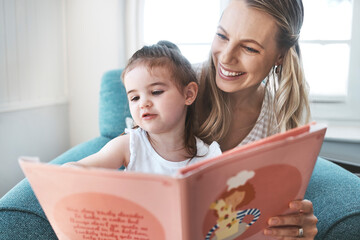 Book, family and love with a mother and daughter reading a story on a couch in the living room of their home together. Children, love and education with a woman and daughter bonding over a storybook - Powered by Adobe