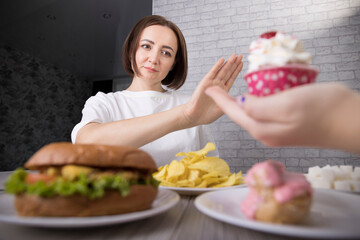 Portrait of a beautiful middle-aged brunette woman promoting the rejection of unhealthy diet and harmful junk products