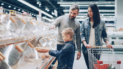 Fototapeta na wymiar Helpful son is helping his parents to buy bread . Shopping together concept.