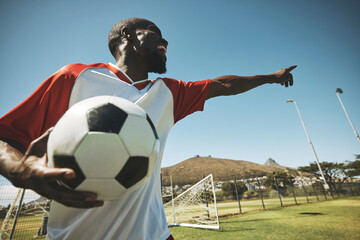 Soccer, football player and black man on a sports field with ball for game or match. Fitness, happy captain male and cardio training of an athlete outdoor for exercise with energy and motivation