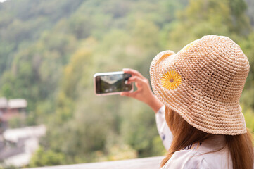 A young woman can't see a face in a hat playing with a mobile phone