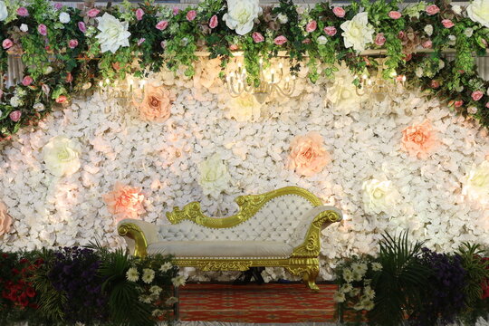 Simple Stage Decoration In White And Yellow Theme With A White Bridal Couch And A Semi Circle Yellow Lily Flower Arch Behind The Couch