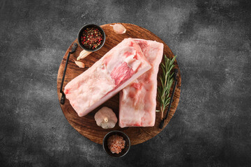 Two pieces of raw pork lard with spices on wooden board, top view - obrazy, fototapety, plakaty
