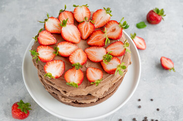 Naked chocolate cake with cream and fresh strawberries on top. Rustic style. Selective focus. Copy space.