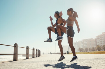 Fitness, nature and couple exercise in beach park, jump wellness and outdoor cardio workout on promenade. Motivation, health and sport partnership or friends in sports training or active lifestyle