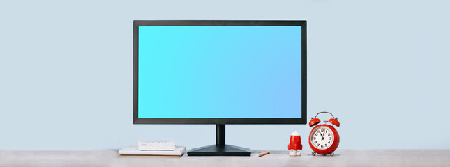 Computer blue monitor mockup for your design and alarm clock rocket and calculator on desk at modern office. Contemporary workplace or home. Office hours working day banner