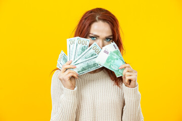 Portrait of Cheerful Young Winsome Woman Holding Stack of Money Banknotes and Celebrating Isolated over Yellow Background