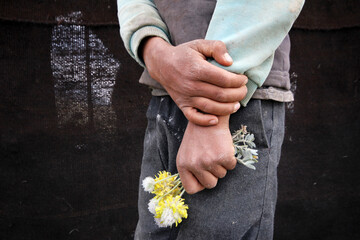 dirty boy holding a flower