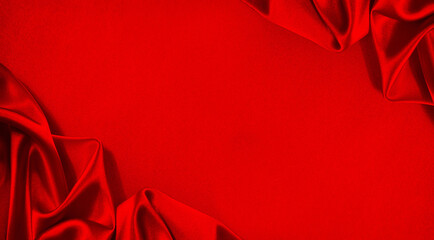Red silk satin. Beautiful soft folds. Shiny fabric. Bright luxury background. Space for design....