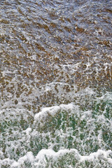 Foamed water top view with bubbles. Water foam abstract background texture. Waves surface closeup.