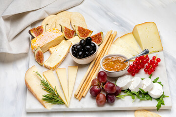 Cheese plate with soft and hard cheeses brie, camembert, pecorino, with jam, olives, Figs and crackers	