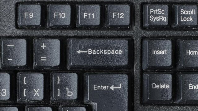 Male finger presses the backspace key on the keyboard many times, macro