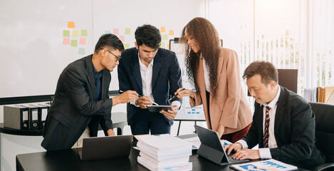 Office colleagues have a casual discussion. During a meeting in a conference room, a group of business teem sit in the conference room new startup project at office.