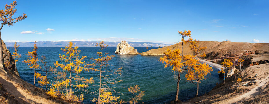 Baikal Lake on sunny autumn day. Panoramic view of the coast of Olkhon Island, the beach near the village of Khuzhir and Shamanka Rock. Autumn travel and outdoor recreation