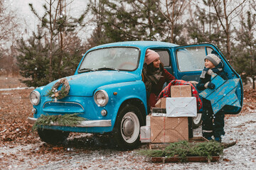 child Decorated with a blue retro car with festive Christmas tree branches, gift boxes in craft...