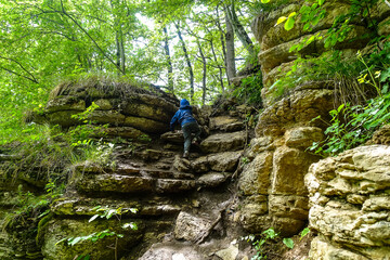 A little boy on the background of rocks in a picturesque forest on the way to the eagle shelf....