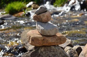 Fototapeta na wymiar Hito de piedras grises y marrones en la orilla de un rio