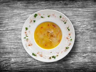chicken soup on wooden background, top view