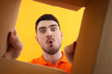 Concept of delivery, surprise, gift, young man opened a cardboard box