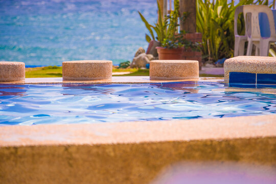 Swimming pool tropical resort spot facing the sea. Summer vacation vibes tourism destination