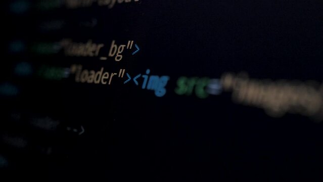 4K Close-up shot HTML tag code on PC Monitor scroll down. Background concept for programming and coding web development. Side view, macro static shot. Orange and green letters.
