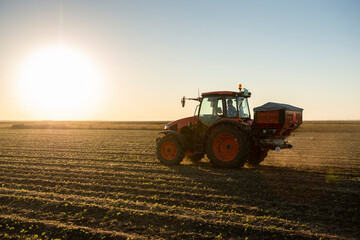 Obraz premium Tractor spreading artificial fertilizers