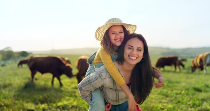 Family, farm and fun with a girl and mother playing on a grass meadow or field with cattle in the background. Agriculture, sustainability and love with a woman and her daughter enjoying time together