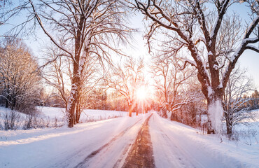 View of the sunrise in the morning on the country snowy road.