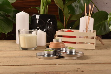 Fototapeta na wymiar Podgrzewacze na ekspozytorze na stole ze świeczkami i drewnianym koszykiem w tle