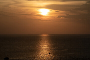 Obraz premium Sunset on the sea and through the clouds over. Tranquil seascape with the horizonal skyline.