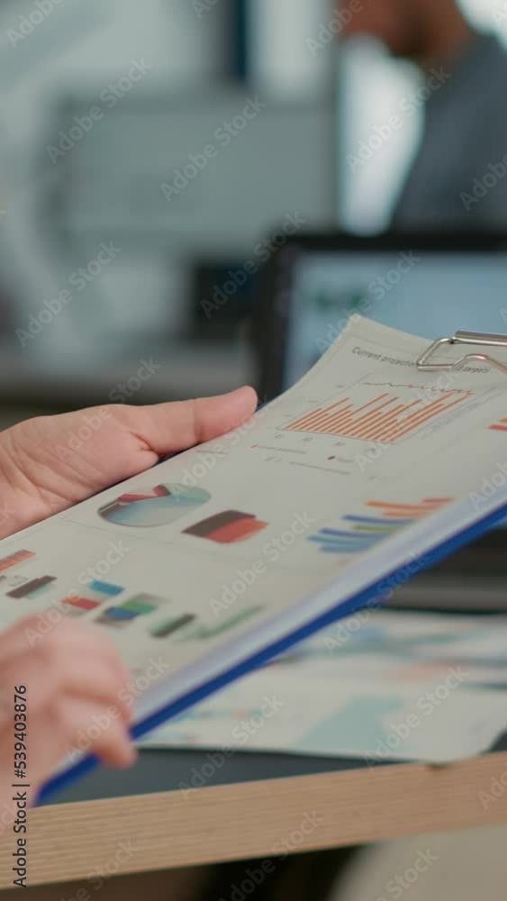 Poster closeup of woman hands holding clipboard with papers looking at pie chart and business profit data i