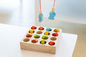 Kids are playing and finding the matched number in the wooden magnetic fishing game, using wooden...