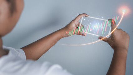 Hologram image of a candlestick chart from a phone on a person's hand. Offer trading concept, investment ideas