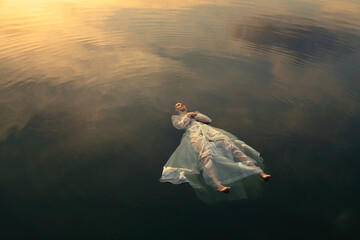 Dead Ophelia in lake waters at sunset