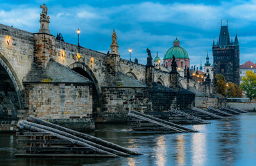 The historical Charles Bridge over Vltava river in Prague in blue hour in autumn. 