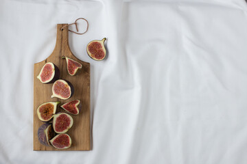 fig halves on a wooden board on a white background