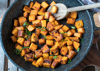 Pan fried cubed pumpkin in a frying pan