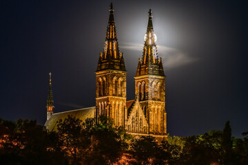 Fototapeta na wymiar Full moon over the illuminated Basilica of St. Peter and St. Paul on Vysehrad hill in Prague.
