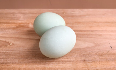 unpeeled salted eggs on wooden table