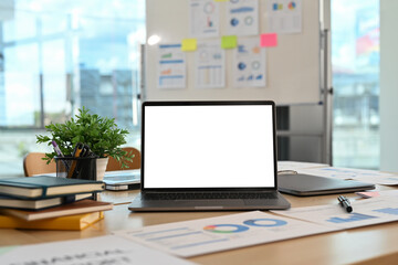 Modern corporate office interior, laptop computer and financial document on wooden table