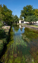 Fototapeta na wymiar Water canal of L'Isle-sur-la-Sorgue summertime, venice of provence. South of France, Europe