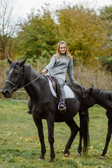 Fototapeta premium Woman on a horse at rancho. Horse riding, hobby time. Concept of animals and human