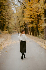 Fototapeta na wymiar Woman walking in the autumn park, a healthy lifestyle, walk, exercise